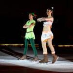 Two people dressed up in costumes on an ice rink.