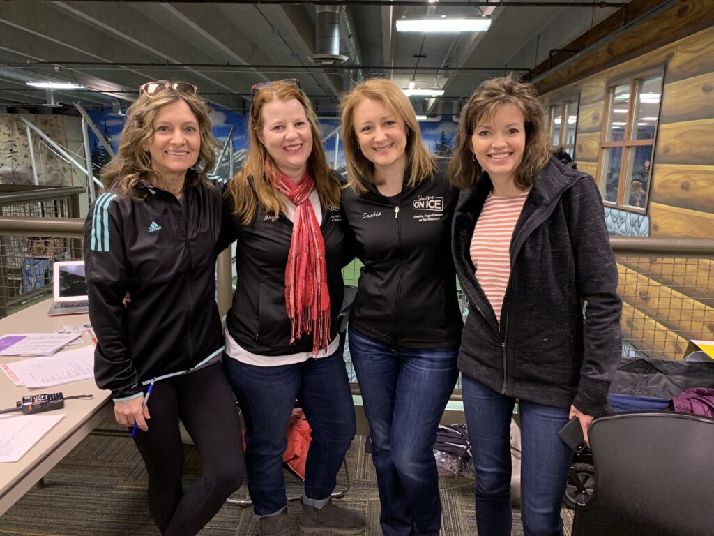 Four women posing for a photo in an office.