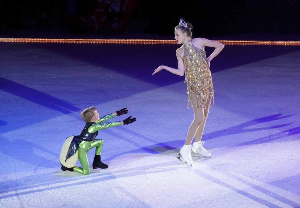 A woman and a kid performing on the ice stage