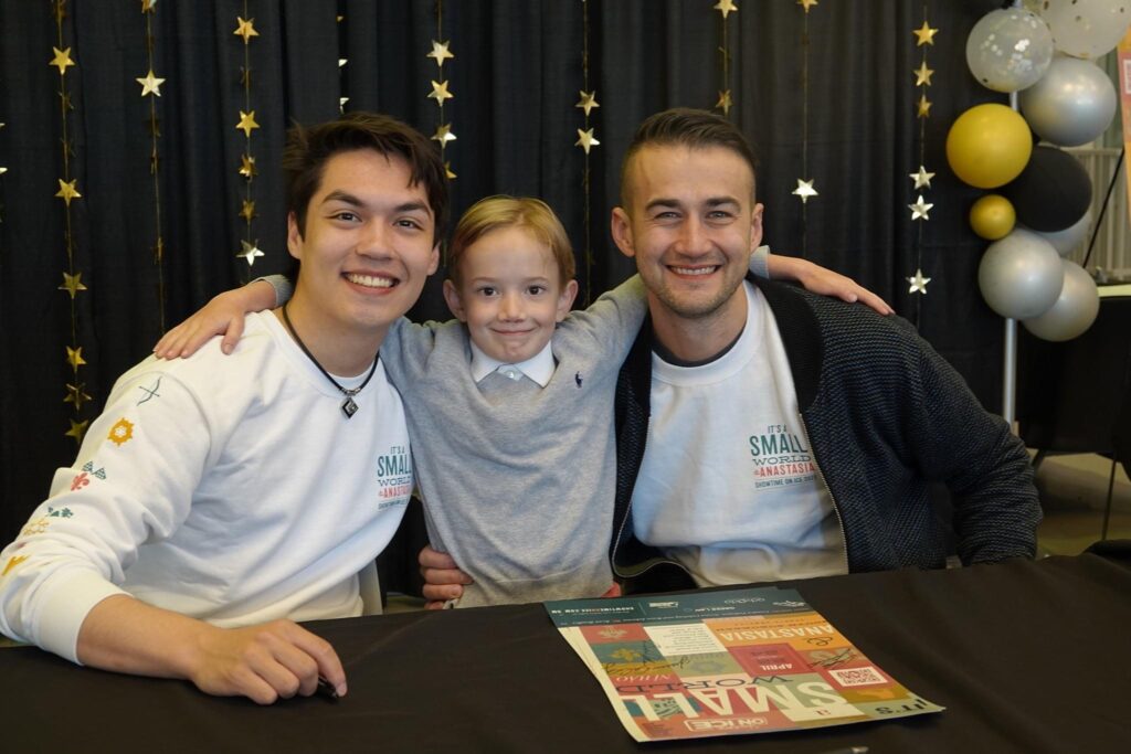 A kid posing with the two small world volunteers