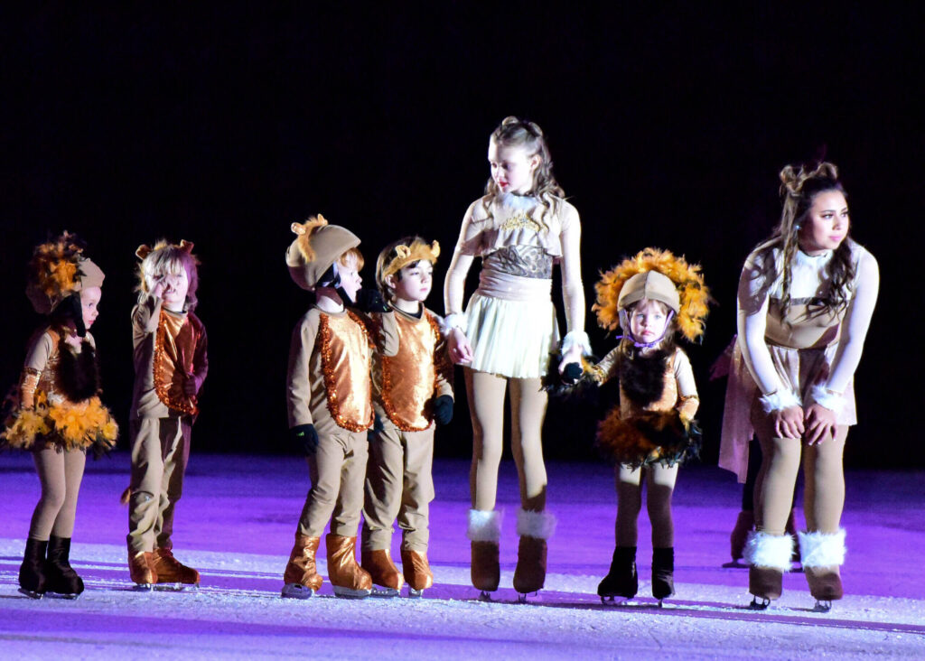 Kids in different costumes performing on the stage