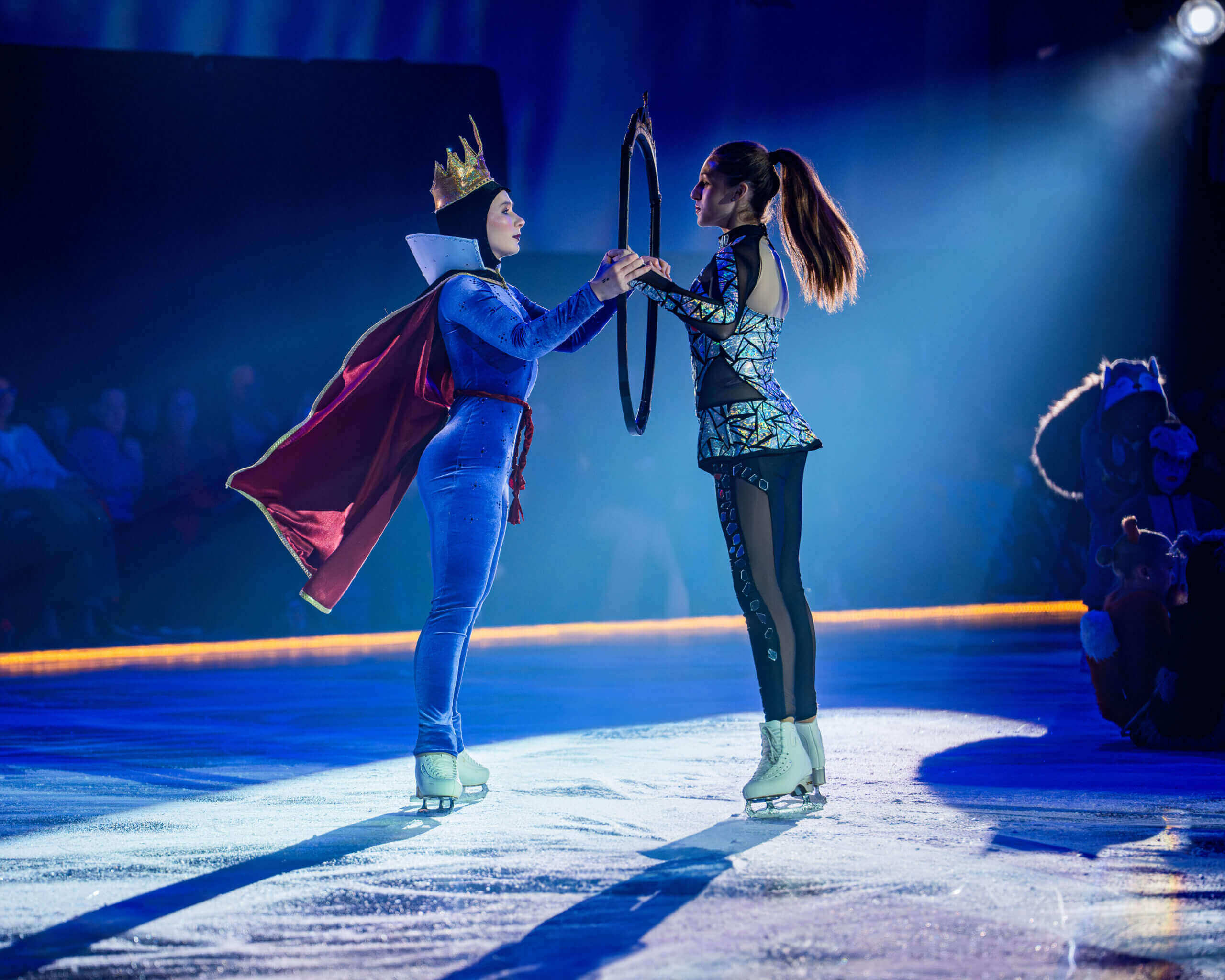 Two ice skaters perform on stage.