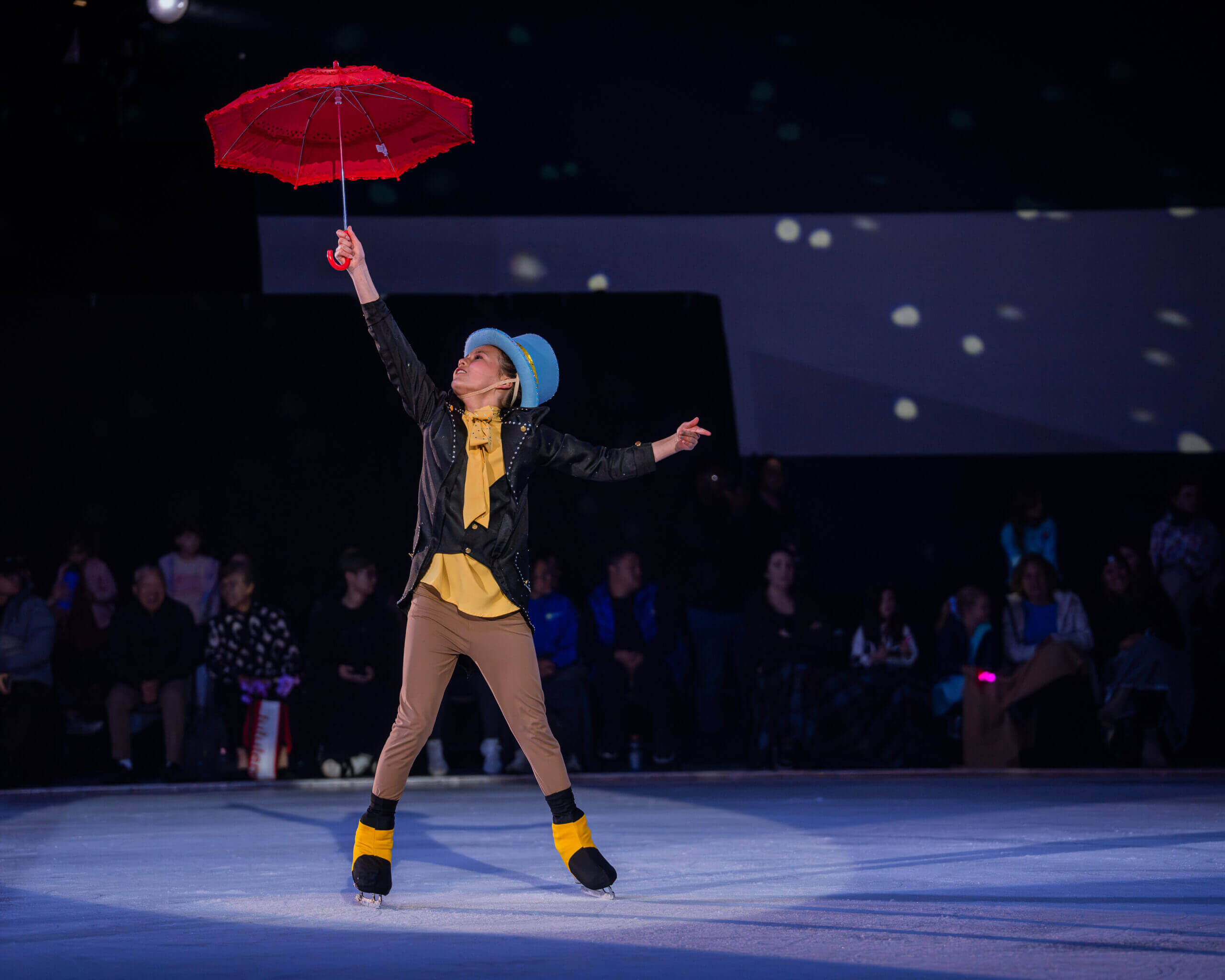 Figure skater performing with red umbrella.